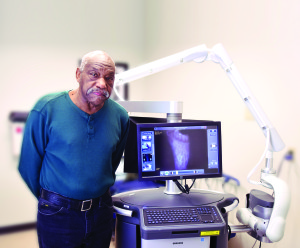 Charles Jones stands with the LUNA system, which helped with the treatment of his diabetic foot ulcer.