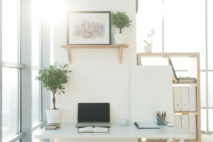 Side view picture of studio workplace with blank notebook, laptop. Designer comfortable work table, home office