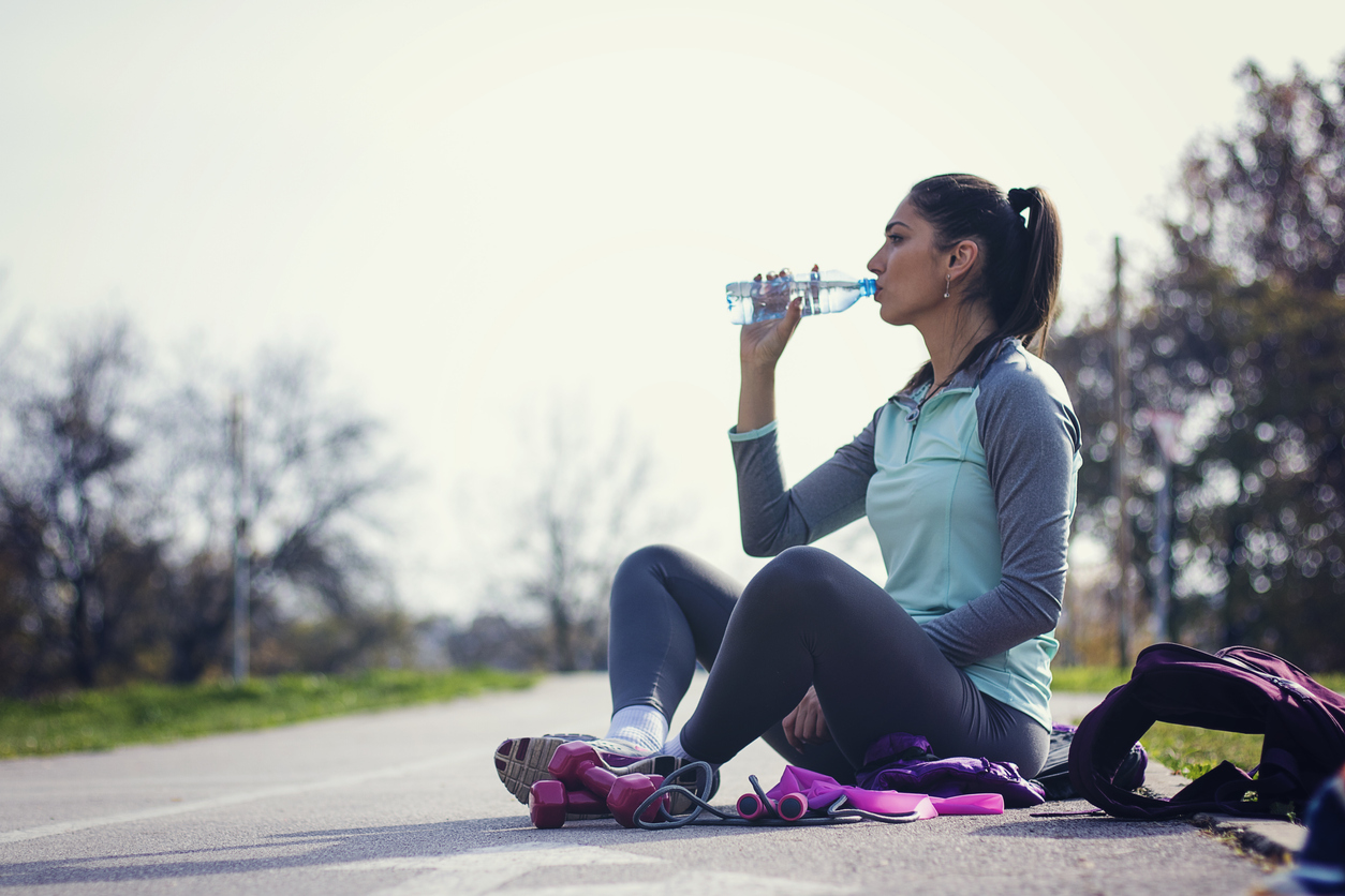 Fitness woman drinking water from bottle